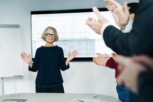 Businesswoman being applauded for successful presentation